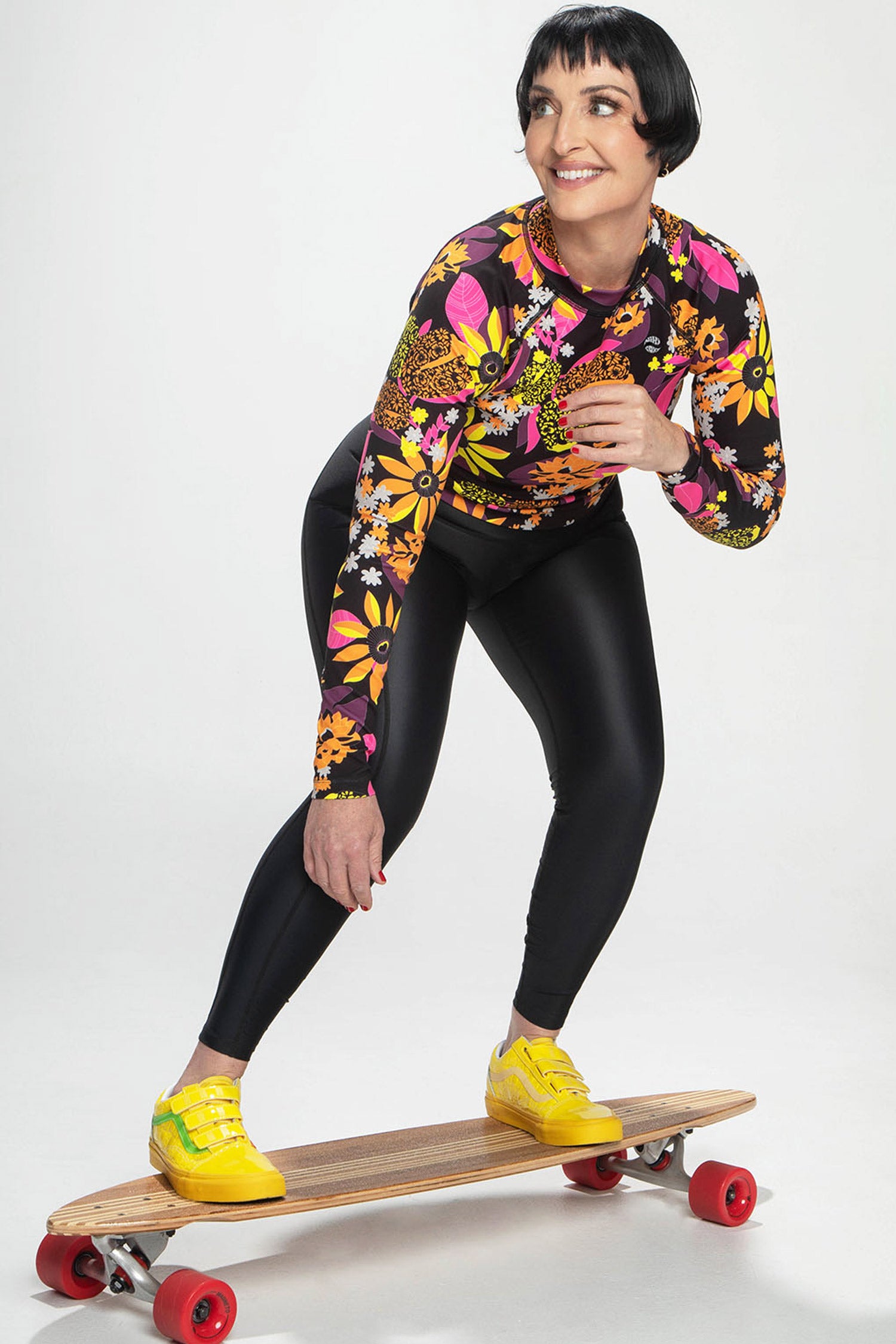 Eco-friendly women’s rash guard paddling on surfboard